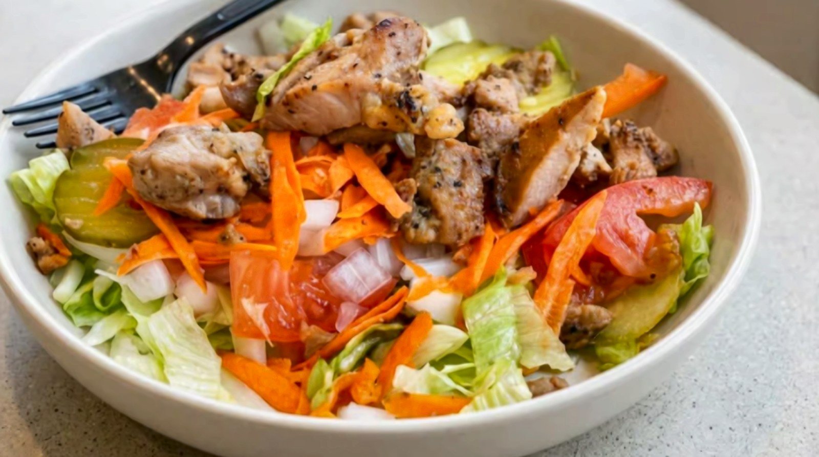 Grilled chicken salad with carrots, tomato and lettuce
